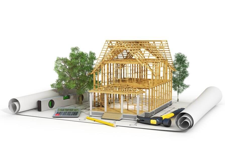 Modèle de maison en bois avec plans et outils de construction autour.